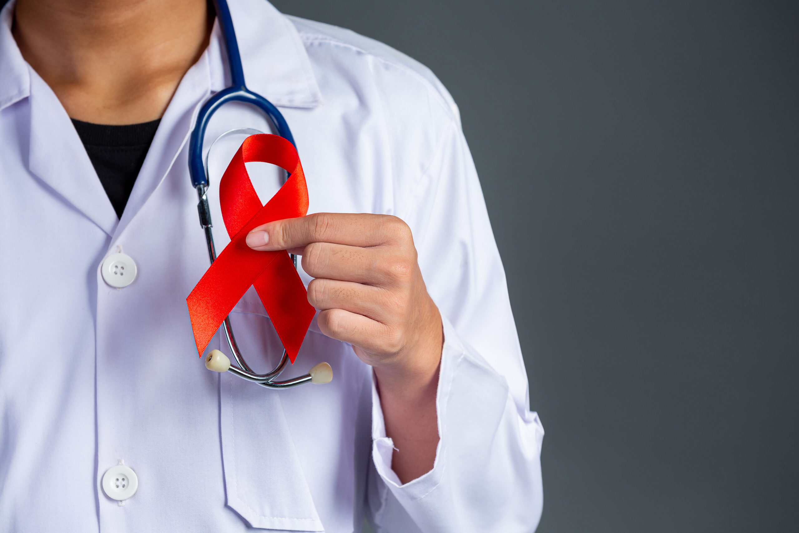 The doctor holds a red ribbon, HIV awareness awareness, World AIDS Day and World Sexual Health Day.