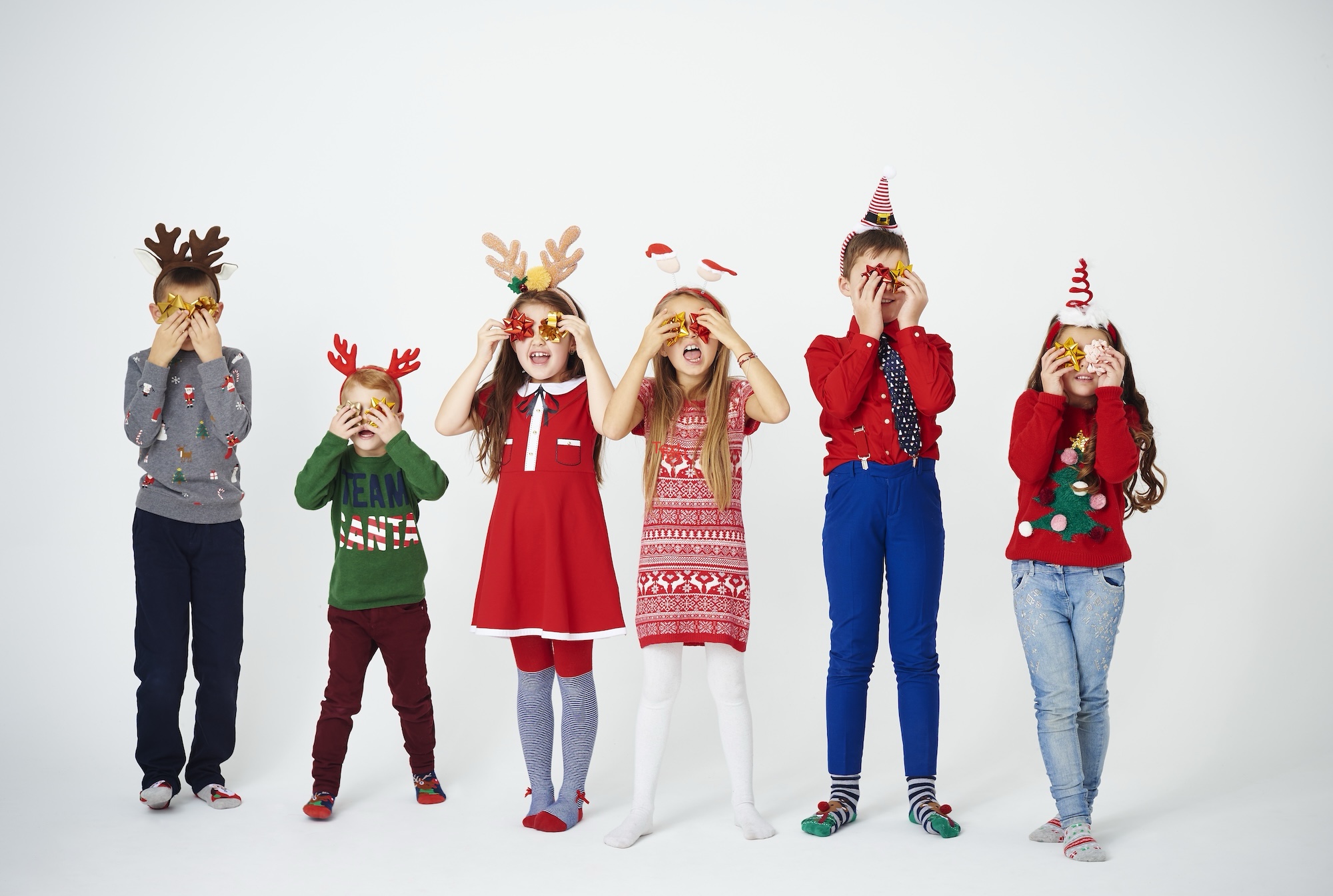 Playful children holding bow in front of eyes