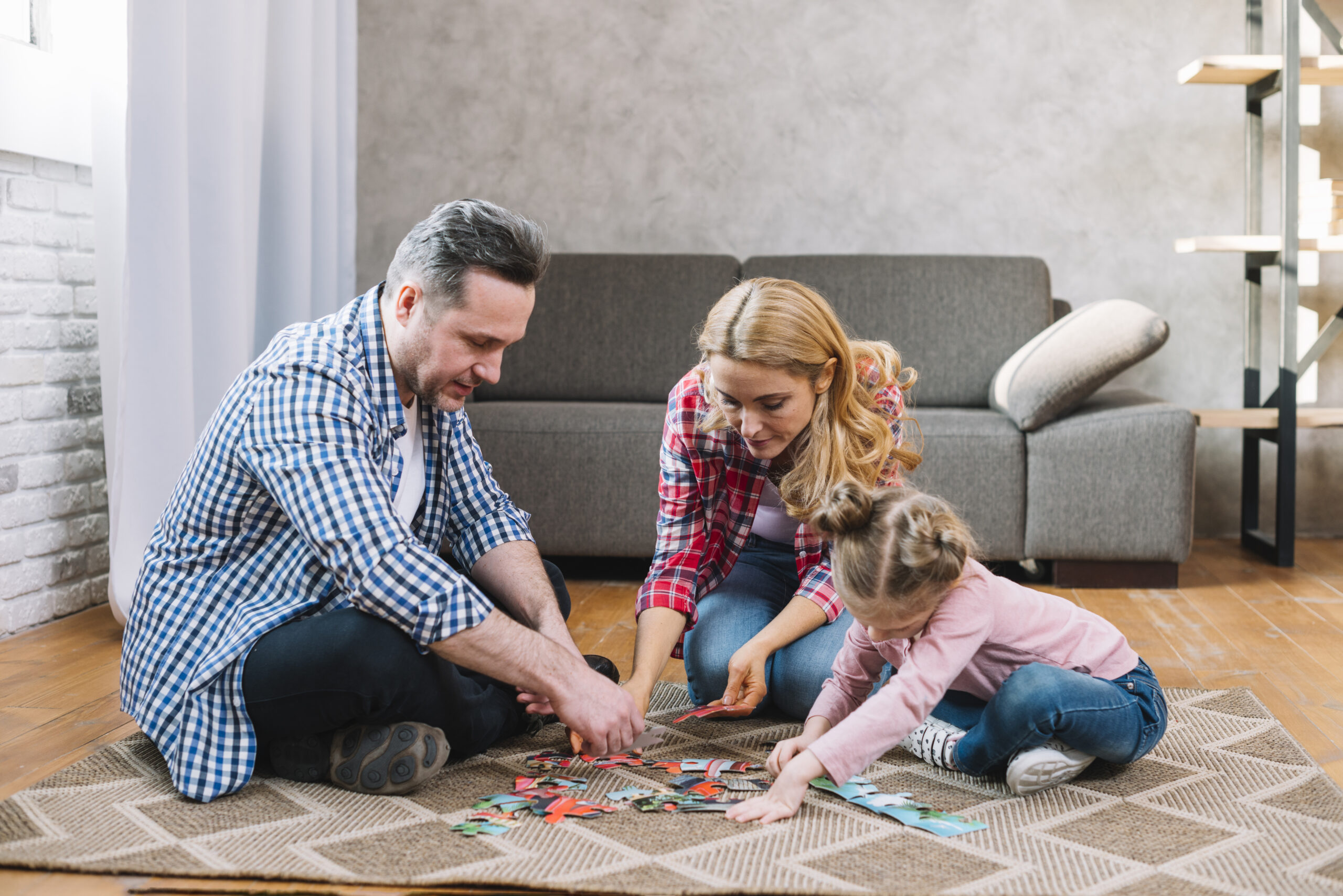 mother-father-playing-puzzle-pieces-with-their-daughter