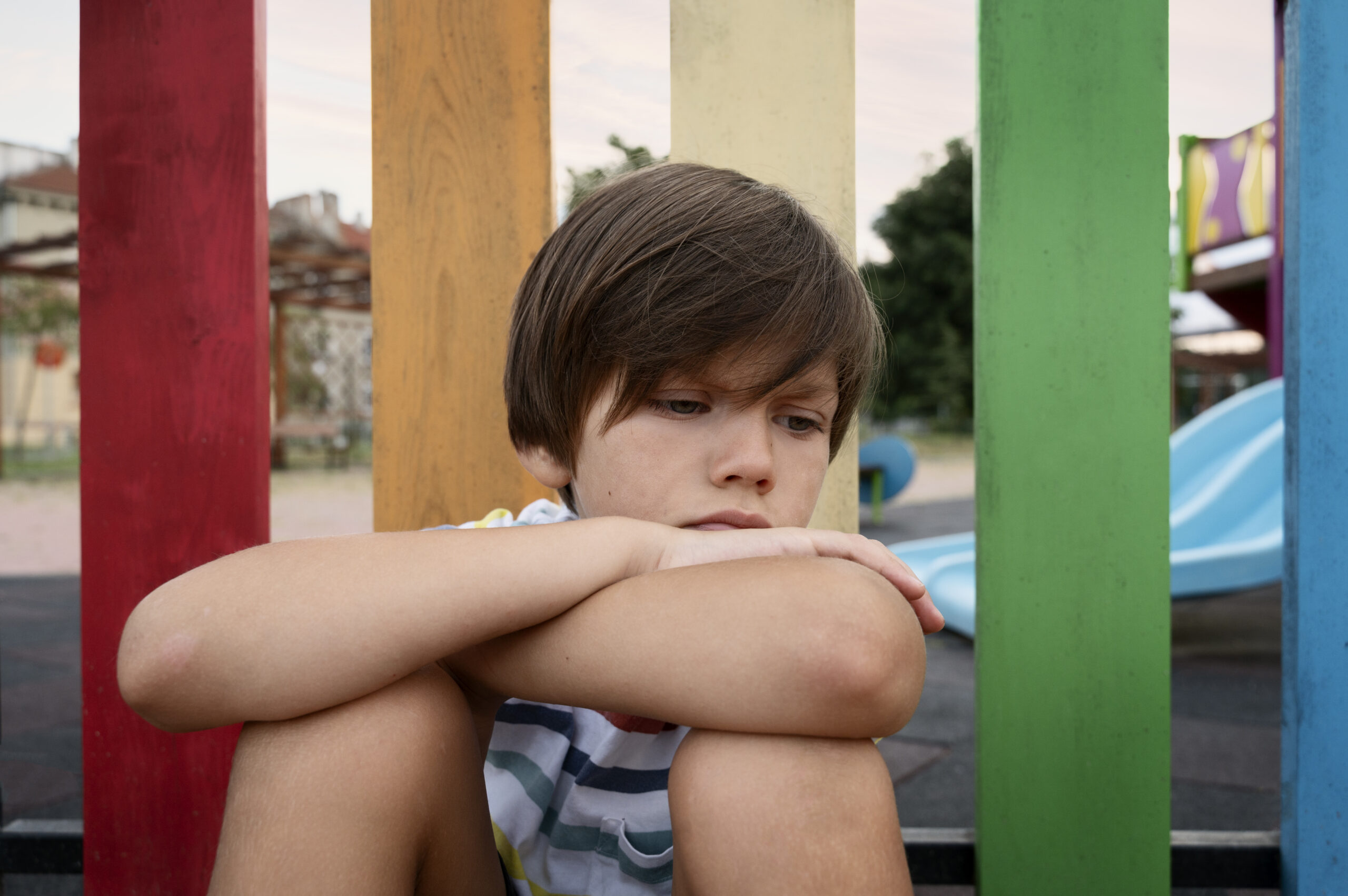 medium-shot-sad-kid-sitting-outdoors