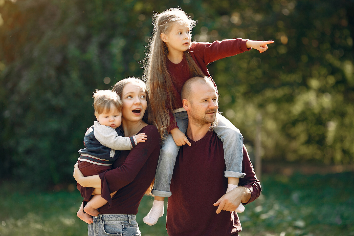 Family in a autumn park. Woman in a red sweater. Cute childrens with parents