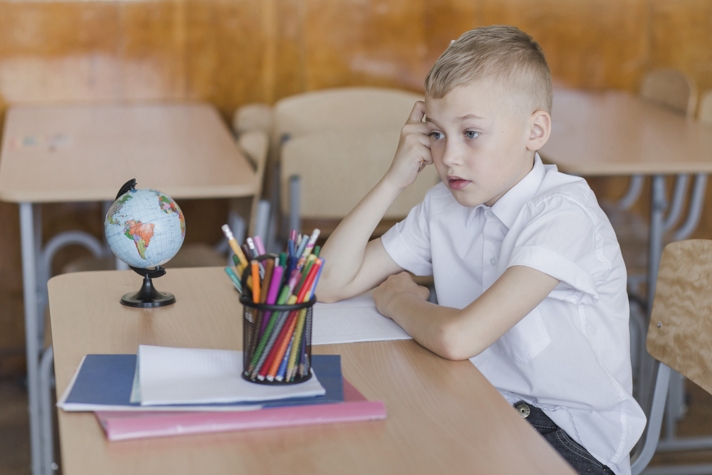 thoughtful-boy-sitting-desk