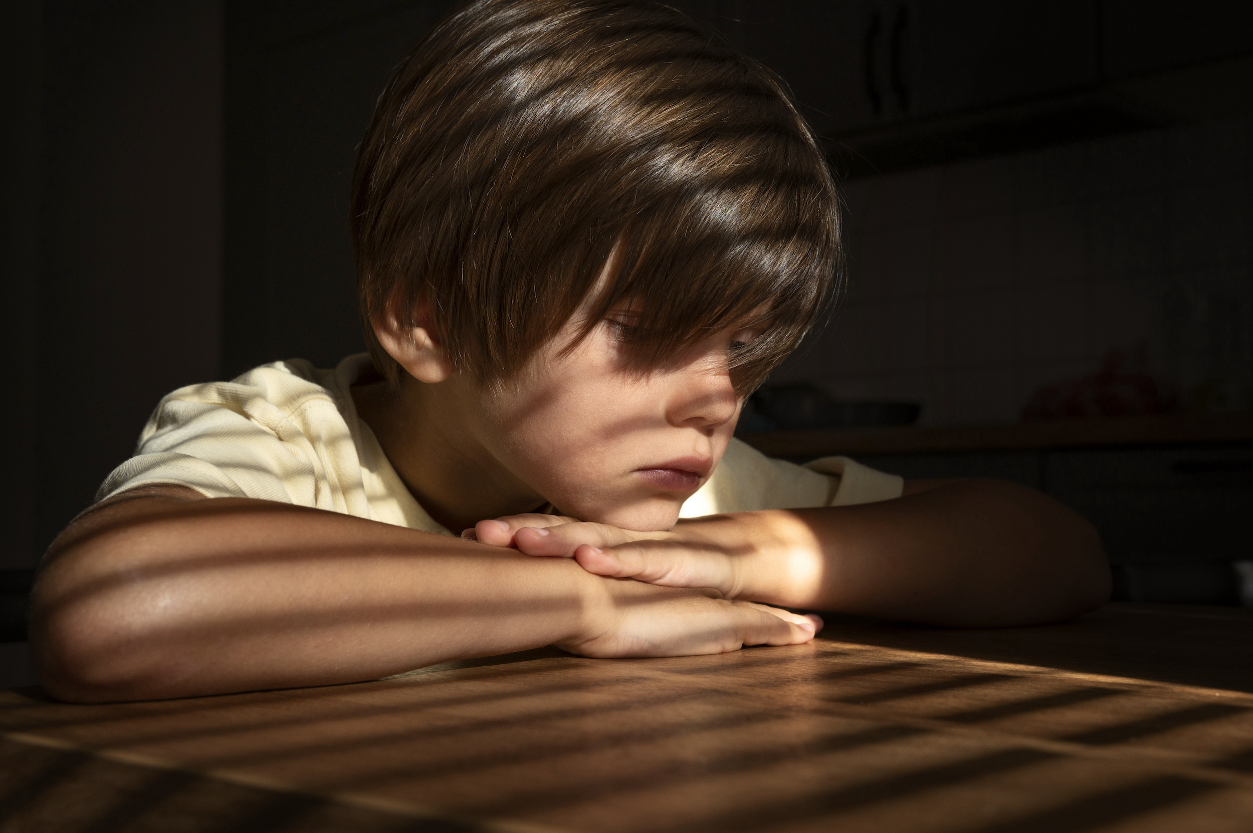 side-view-sad-boy-sitting-indoors